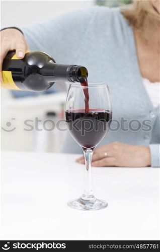 Close Up Of Woman Pouring Large Glass Of Red Wine