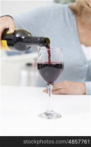 Close Up Of Woman Pouring Large Glass Of Red Wine