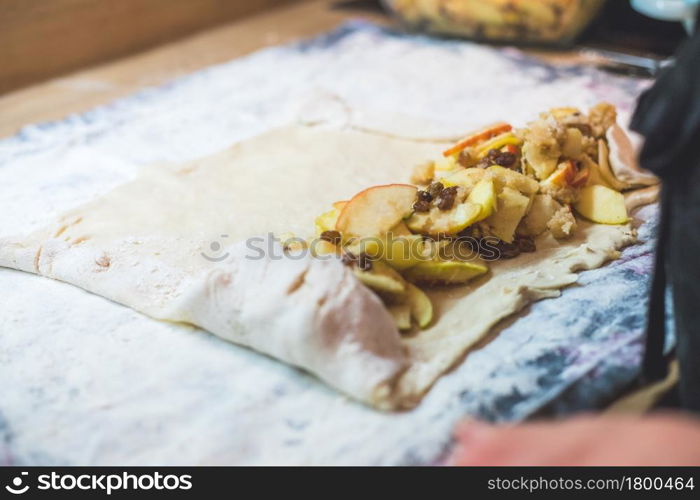 Close up of woman preparing traditional Austrian apple strudel in the kitchen