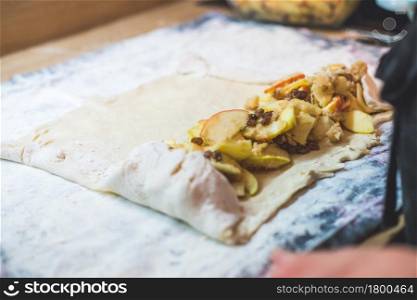 Close up of woman preparing traditional Austrian apple strudel in the kitchen