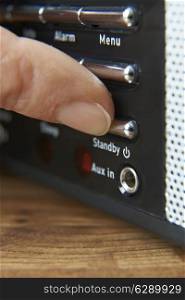 Close Up Of Woman Pressing Standy Button On Radio