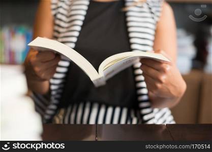 Close up of woman reading a book in library.