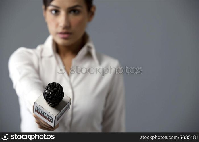 Close-up of woman reporter holding microphone