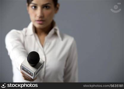 Close-up of woman reporter holding microphone