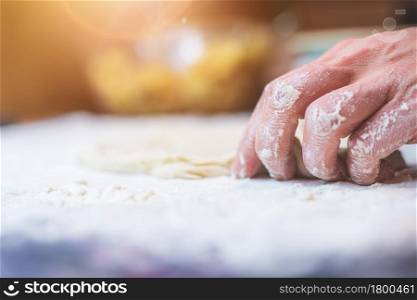 Close up of woman rolling traditional dough in the kitchen