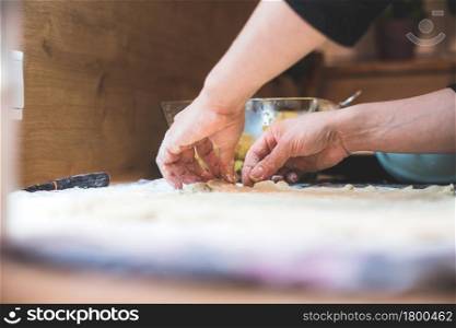 Close up of woman rolling traditional dough in the kitchen