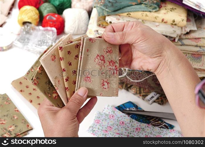Close up of woman&rsquo;s hand sewing patchwork
