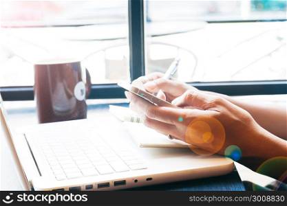 Close up of woman&rsquo;s hands using mobile phone and laptop, Online marketing or shopping concept