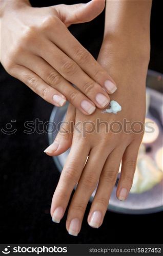 Close-up of woman rubbing lotion on hands