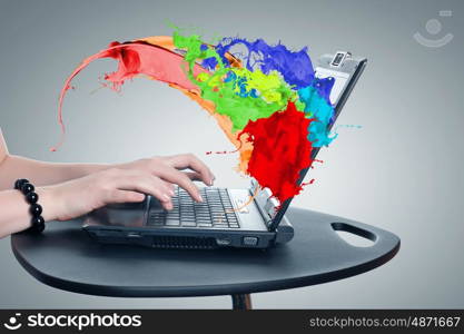 Close up of woman's hands using laptop and splashes out of monitor