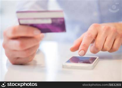 Close Up Of Woman Using Credit Card To Make Purchase On Mobile Phone