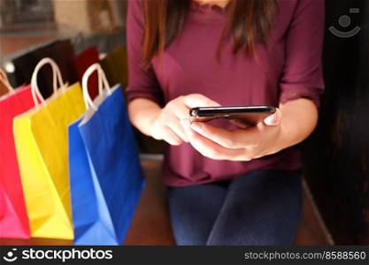 Close-up of woman using her smartphone during shopping