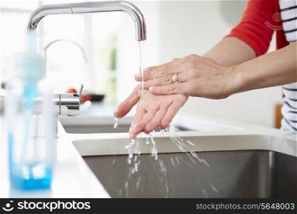 Close Up Of Woman Washing Hands In Kitchen Sink