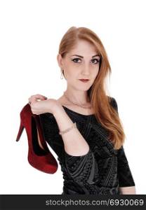 Close up of woman with brunette hair and gays dress holding a redhigh heel over her shoulder, isolated for white background