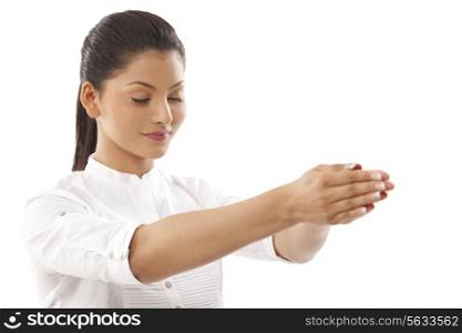 Close-up of woman with hands clasped and eyes closed doing yoga over white background