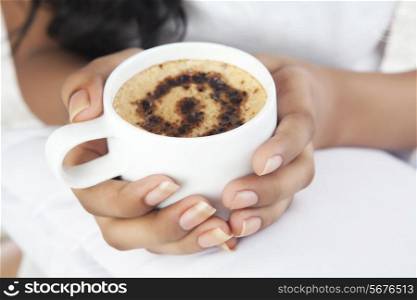 Close-up of womans hands holding a cup of coffee