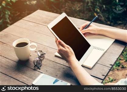 Close up of women hand holding tablet computer with blank copy space screen for your advertising. Hand woman using tablet in coffee shop.