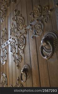 Close-up of wooden doors with decorative metalwork in Lisbon, Portugal.