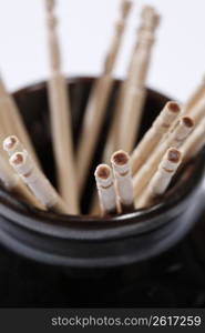 Close up of wooden sticks in black pot