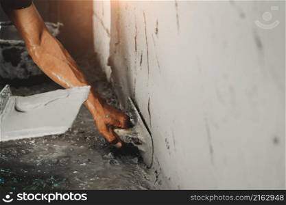 Close-up of worker plastering a cement wall for building house