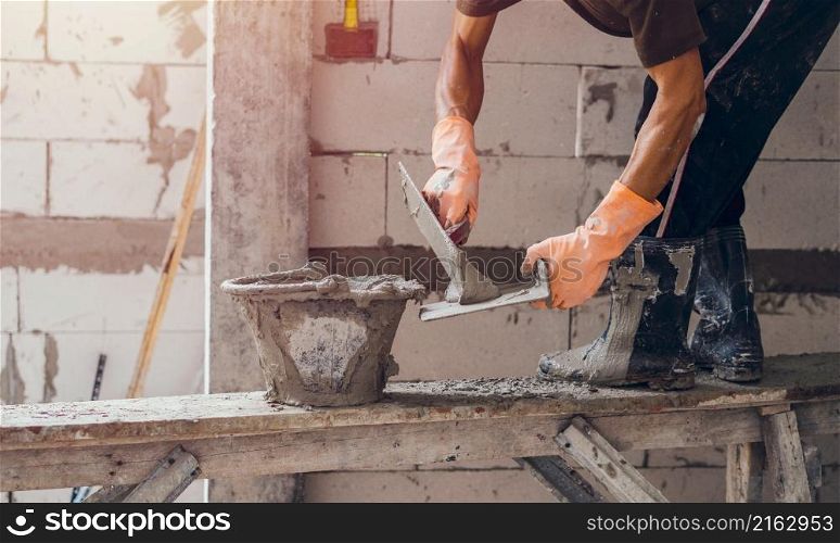 Close-up of worker plastering a cement wall for building house