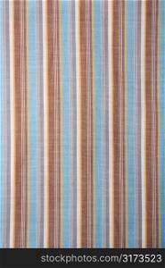 Close-up of woven vintage fabric with blue and brown stripes on cotton.