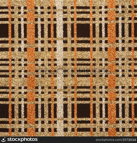 Close-up of woven vintage fabric with brown and gold crossbar pattern.