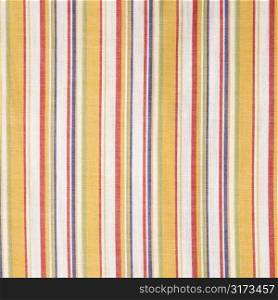 Close-up of woven vintage fabric with colorful stripes on cotton.