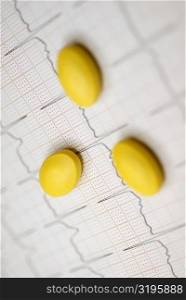 Close-up of yellow pills on a sheet of paper
