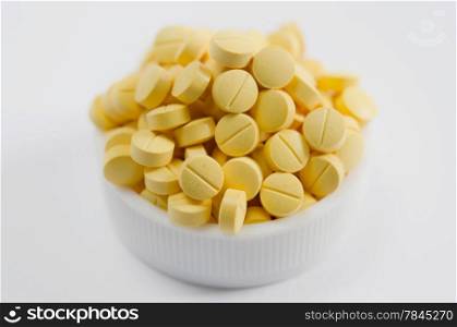 close-up of yellow pills on the white background