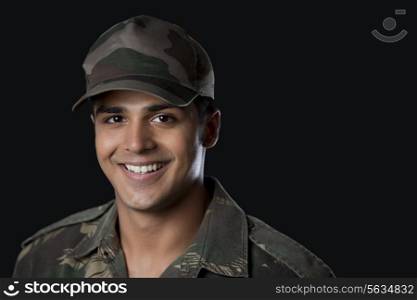 Close-up of young army soldier against black background