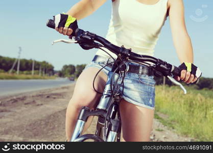 Close up of young beautiful woman riding a bicycle in a park