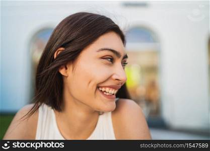 Close-up of young brunette latin woman smiling outdoors in the street. Lifestyle concept.
