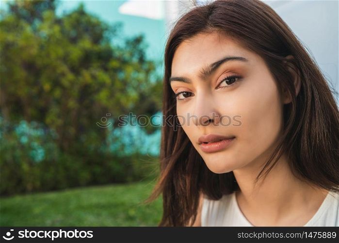 Close-up of young brunette latin woman standing in the park outdoors. Urban concept.