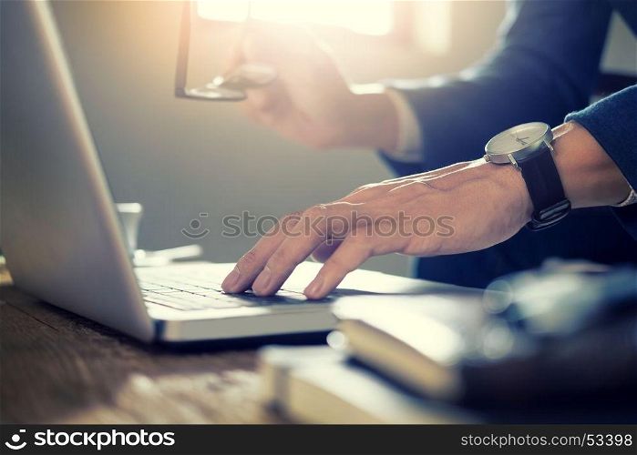 Close up of Young Businessman Working typing On Laptop In Coffee Shop cafe