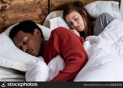 Close-up of young couple sleeping in a comfortable bed at home.