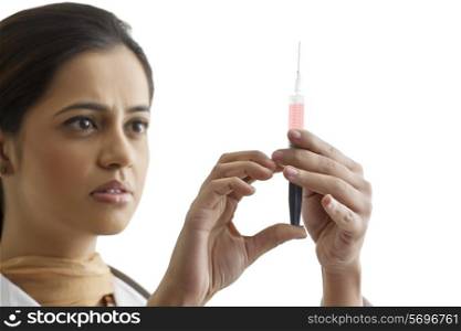 Close-up of young female doctor holding syringe isolated over white background