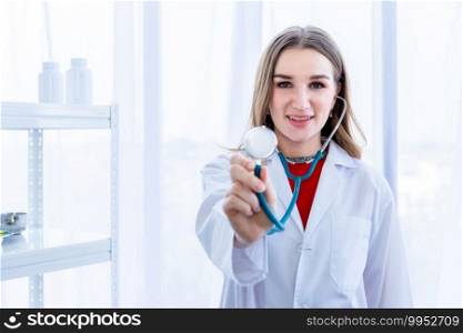 Close-up of young female doctor therapeutic advising smiling face show holding stethoscope with in hospital background.