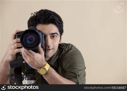 Close-up of young handsome photographer taking a photograph