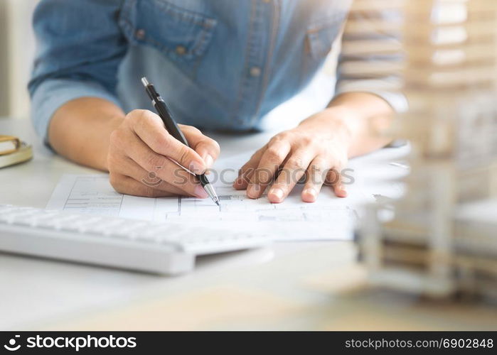 close up of young interior Architect working on blueprint with engineering tools