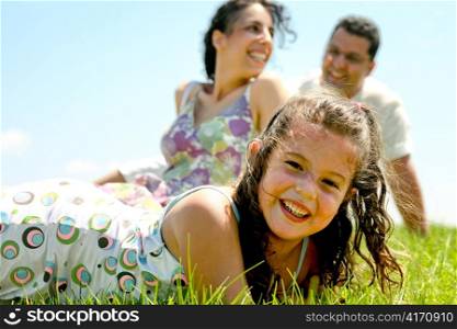 Close-up of young kid with parents relaxing at back