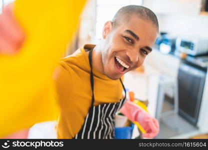 Close up of young latin man cleaning at new home. Housekeeping and cleaning concept.