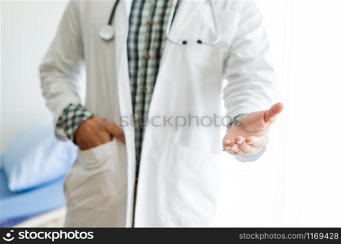 Close-up of Young man doctor therapeutic advising smiling face abstract blur with focus show shake hand with in hospital background