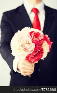 close up of young man giving bouquet of flowers.