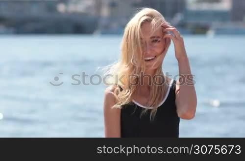 Close up of young sexy blonde woman in swimsuit posing on the beach