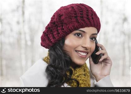 Close-up of young smiling woman having conversation on mobile phone
