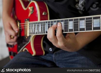 Close-up of young woman&acute;s hand playing guitar