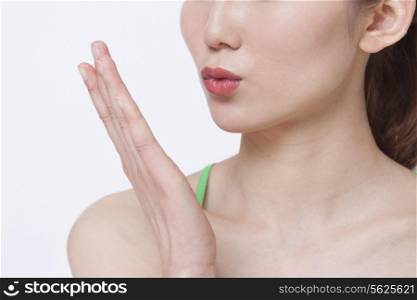 Close up of young woman blowing a kiss, studio shot