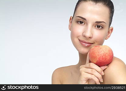 Close-up of young woman holding an orange