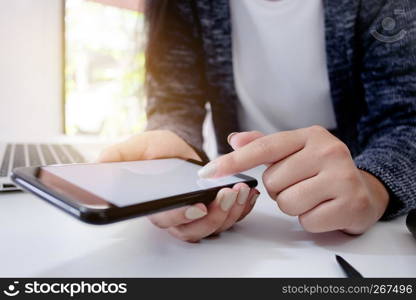 Close up of young woman holding cell phone, using mobile smart gadget